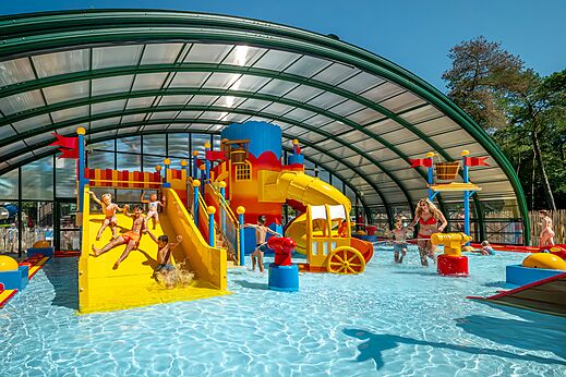 Piscina cubierta con juegos acuáticos y toboganes en CAPFUN De Scheepsbel.