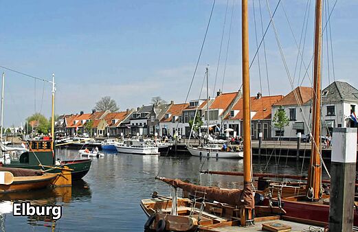 Puerto histórico de Elburg con barcos y casas tradicionales, lugar para visitar.