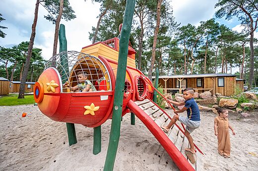 Zona de juegos colorida con niños en el camping CAPFUN De Scheepsbel en Doornspijk.