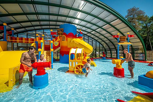 Zona de juegos acuáticos cubierta con toboganes y cañones de agua en el camping CAPFUN De Scheepsbel en Doornspijk.