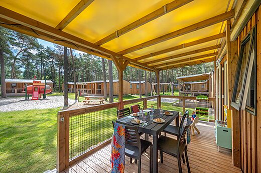 Terraza amueblada de Mobil-home y zona de juegos en el camping CAPFUN De Scheepsbel en Doornspijk.