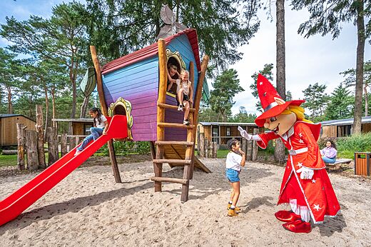 Zona de juegos con tobogán, cabaña y mascota en el camping CAPFUN De Scheepsbel en Doornspijk.