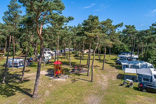 Parcelas de camping sombreadas con parque infantil en el camping CAPFUN De Scheepsbel en Doornspijk.