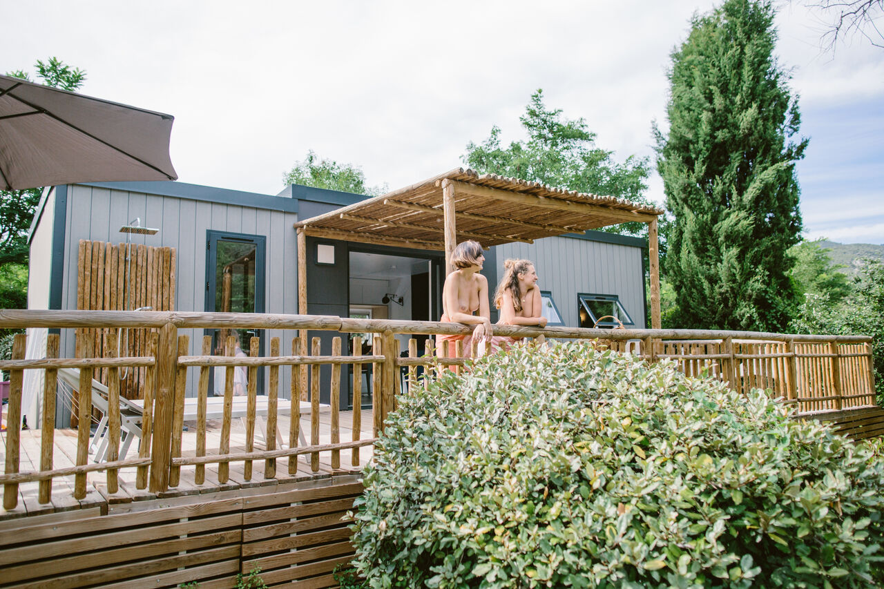 Mobil home moderno, terraza de madera, ducha exterior en camping LIBRANOO Naturiste Belezy.