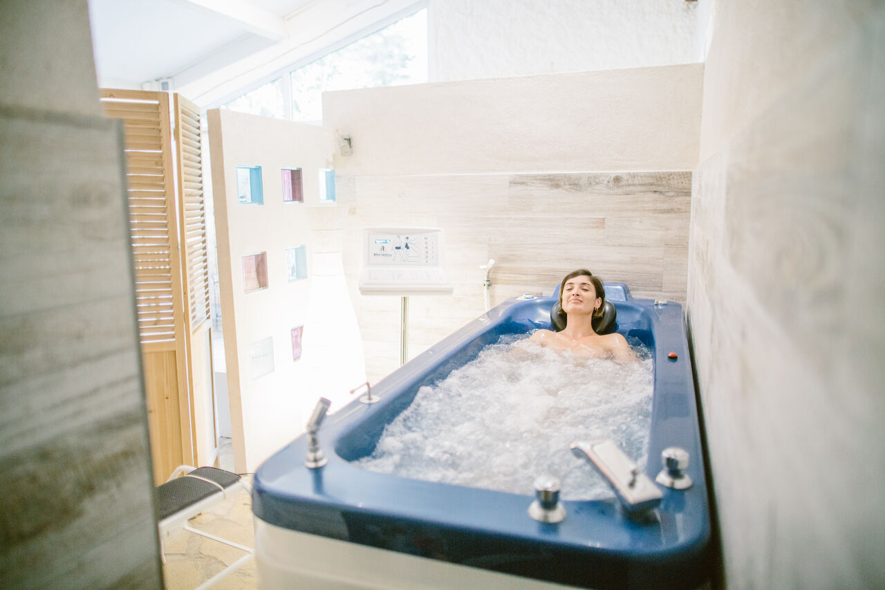 Mujer relaj�ndose en ba�era de hidromasaje en el spa del camping LIBRANOO Naturiste Belezy en B�doin (84).