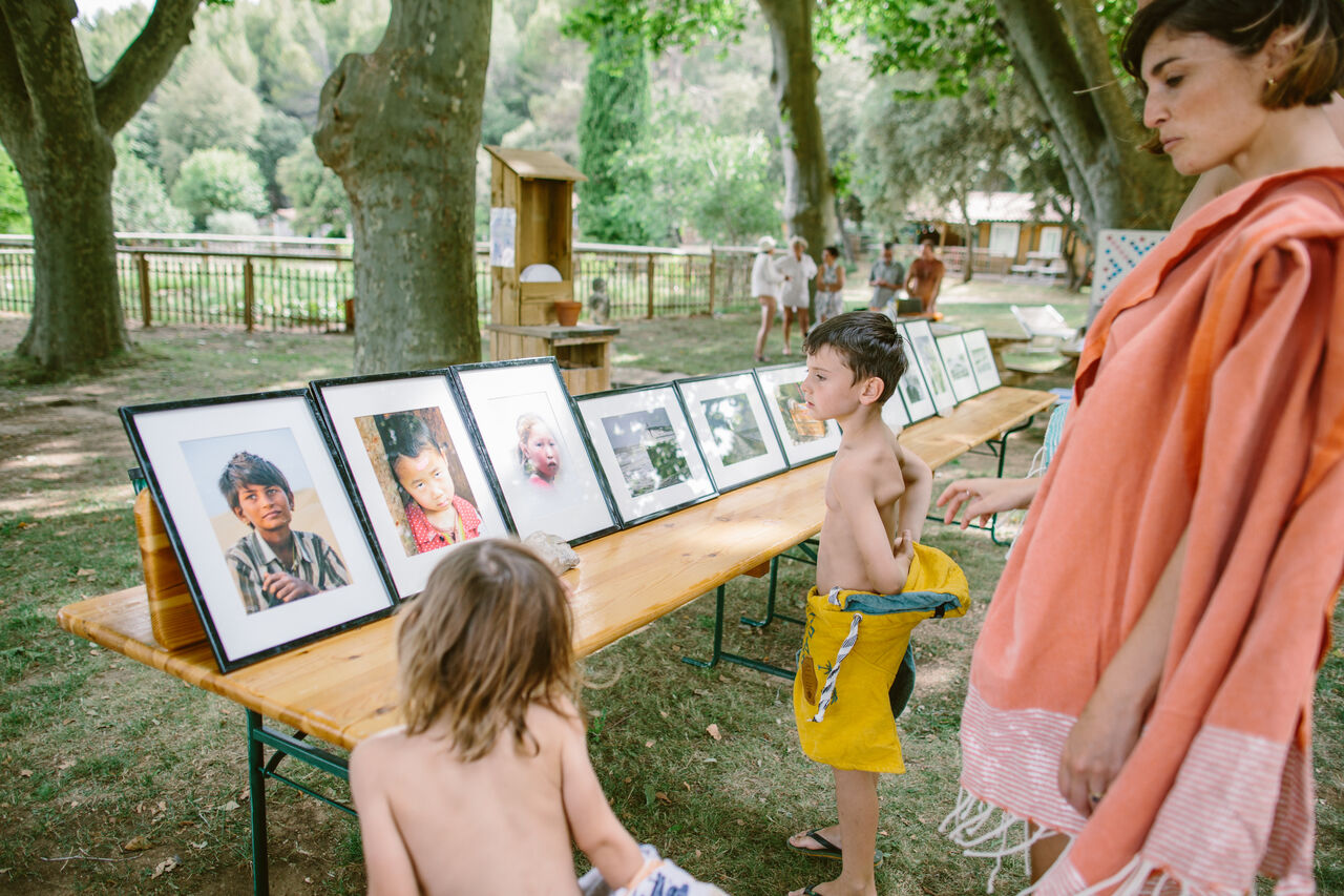 Ni�os viendo exposici�n de fotos al aire libre en camping LIBRANOO Naturiste Belezy en B�doin (84).
