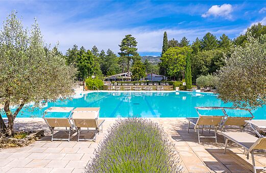 Gran piscina exterior con sillas en el camping LIBRANOO Naturiste Belezy en B�doin (84).