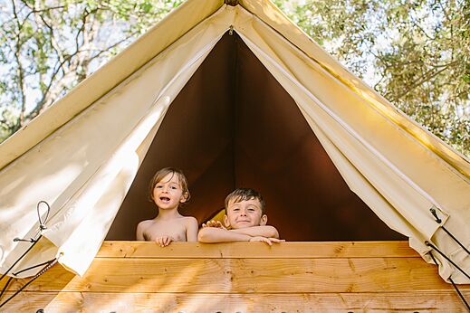 Niños sonrientes en tienda glamping de madera al camping LIBRANOO Naturiste Belezy en Bédoin (84).