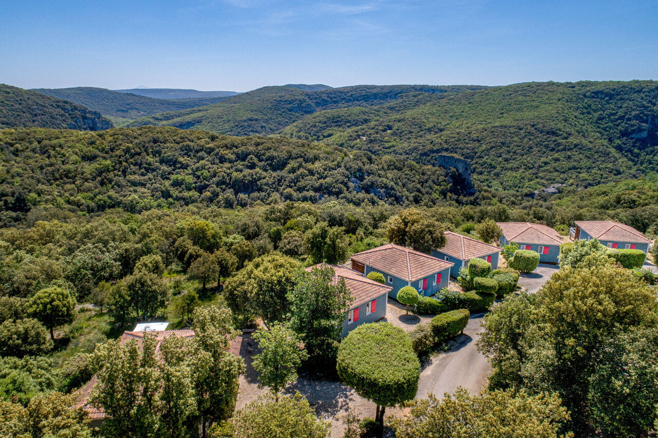 Chalets azules con techos de tejas en plena naturaleza, camping LIBRANOO Naturiste Sabliere en Barjac (30).