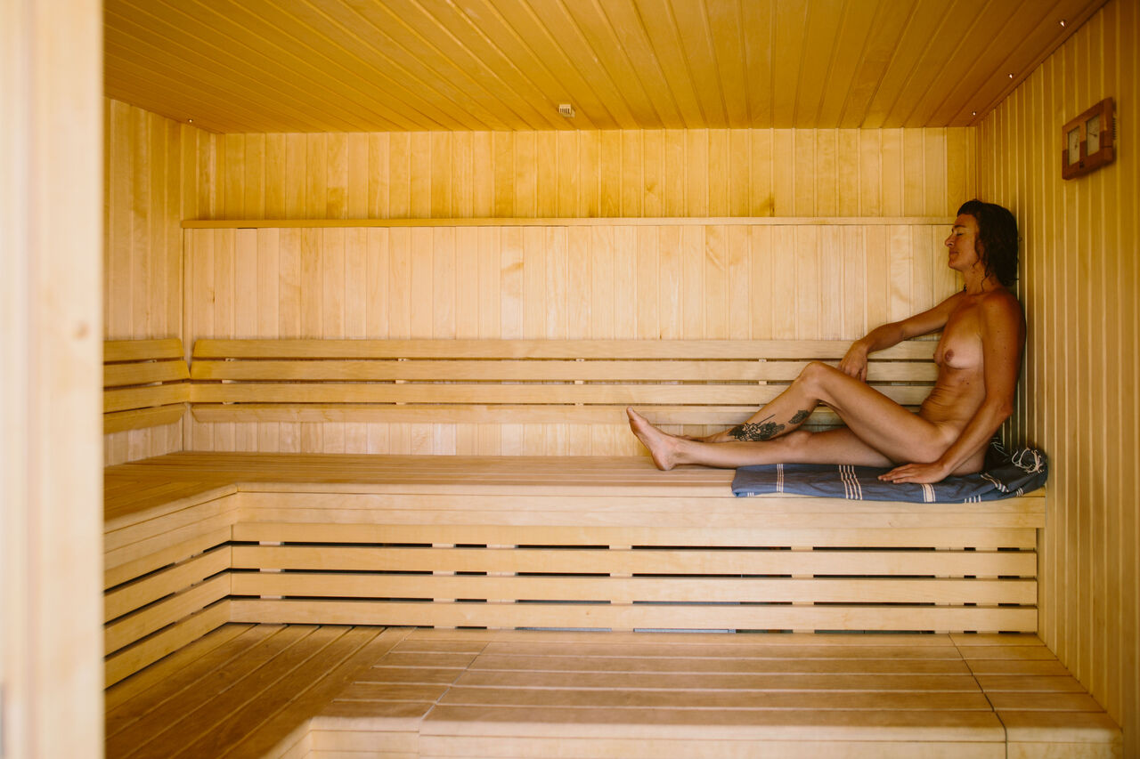 Sauna de madera, persona naturista relajada, camping LIBRANOO Naturiste Sabliere Barjac (30).