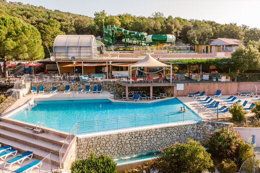 Piscina exterior con toboganes acu�ticos y sillas en el camping LIBRANOO Naturiste Sabliere en Barjac (30).