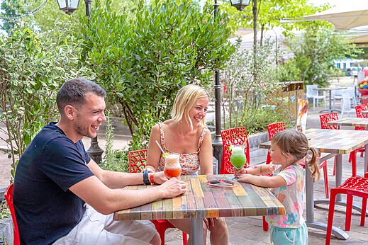 Terraza de restaurante animada en el camping CAPFUN Donjon de Lars en Courseulles-sur-Mer.