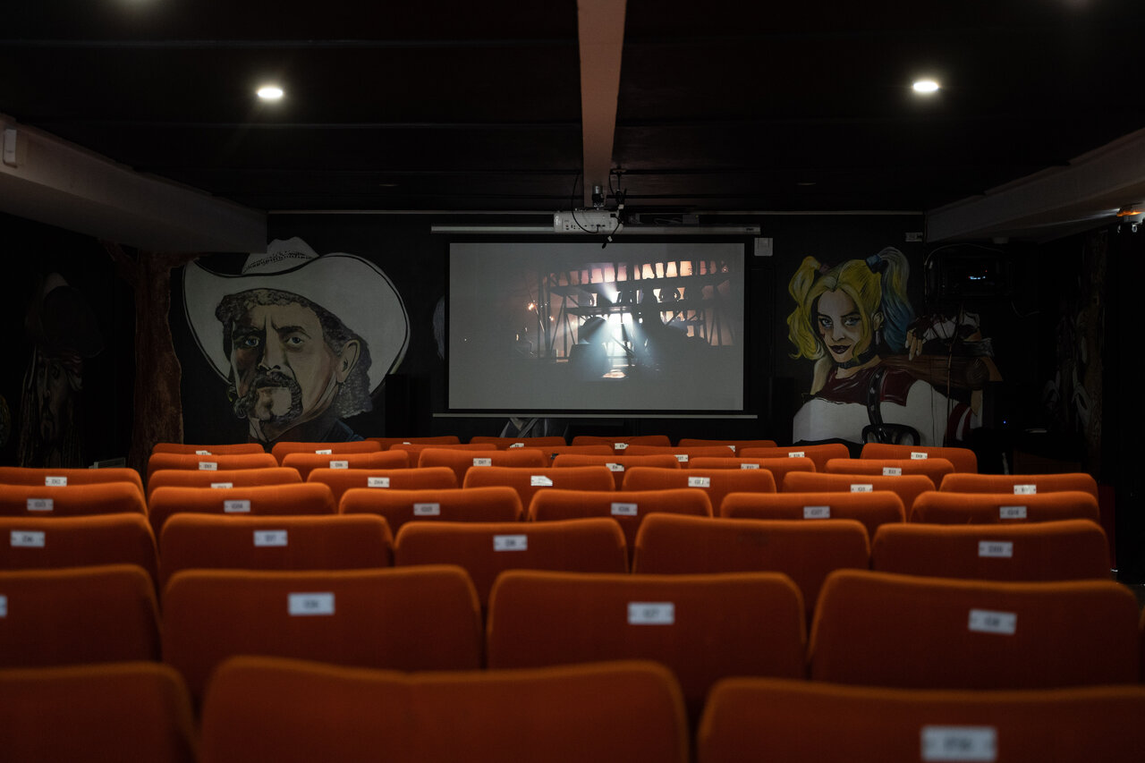 Sala de cine, asientos naranjas, pantalla gigante en CAPFUN Dune Fleurie (80).