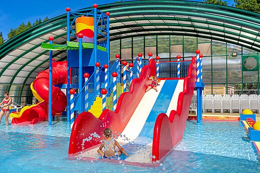 Toboganes acuáticos coloridos y piscina en el camping CAPFUN Dune Fleurie en Quend Plage (80).