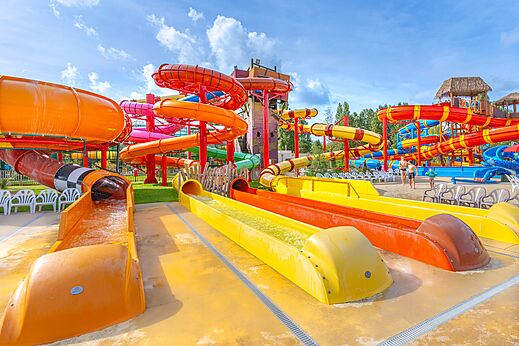 Toboganes acuáticos coloridos y piscina exterior en camping CAPFUN Dune Fleurie Quend Plage (80).