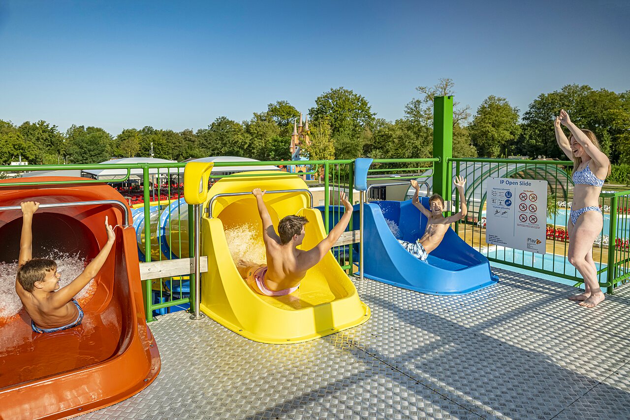 Ni�os y adultos disfrutando de toboganes acu�ticos coloridos en el camping CAPFUN Eibernest en Eibergen.