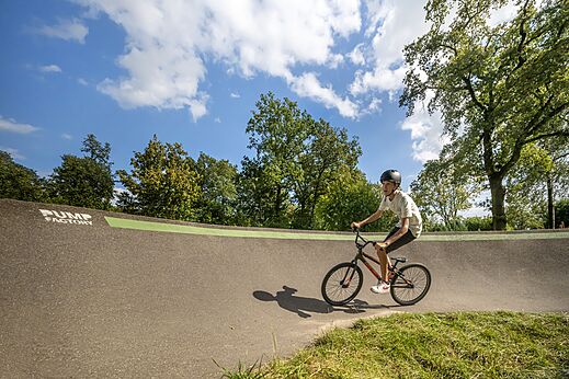 Joven ciclista en pista de pumptrack del camping CAPFUN Eibernest en Eibergen.