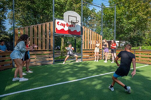Cancha multideporte con jóvenes jugando baloncesto en el camping CAPFUN Eibernest en Eibergen.