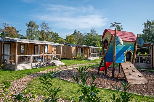 Mobil-homes de madera con terrazas y zona de juegos en el camping CAPFUN Eibernest en Eibergen.