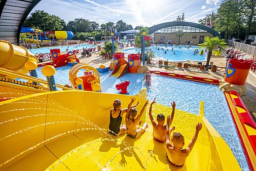 Niños en tobogán acuático gigante y juegos de agua en camping CAPFUN Eibernest en Eibergen.