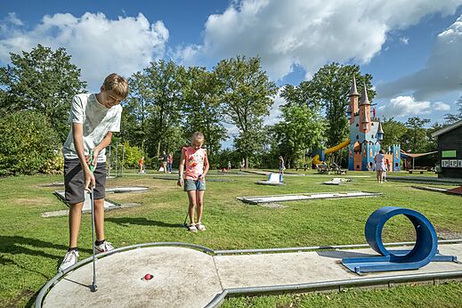 Ni�os jugando al minigolf con castillo de juegos en el camping CAPFUN Eibernest en Eibergen.