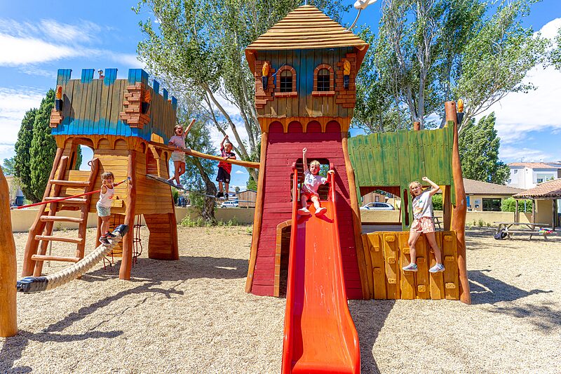 Juego Carabouille - Parque infantil de madera con tobog�n y ni�os felices en el camping VAGUES OCEANES Elys�e en Le Grau du Roi (30).
