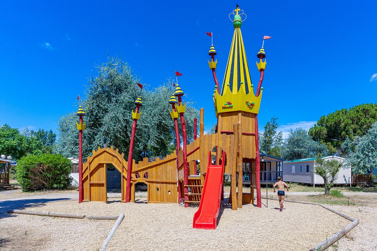Parque infantil castillo, tobog�n, ni�o y mobil-homes en el camping VAGUES OCEANES Elys�e.