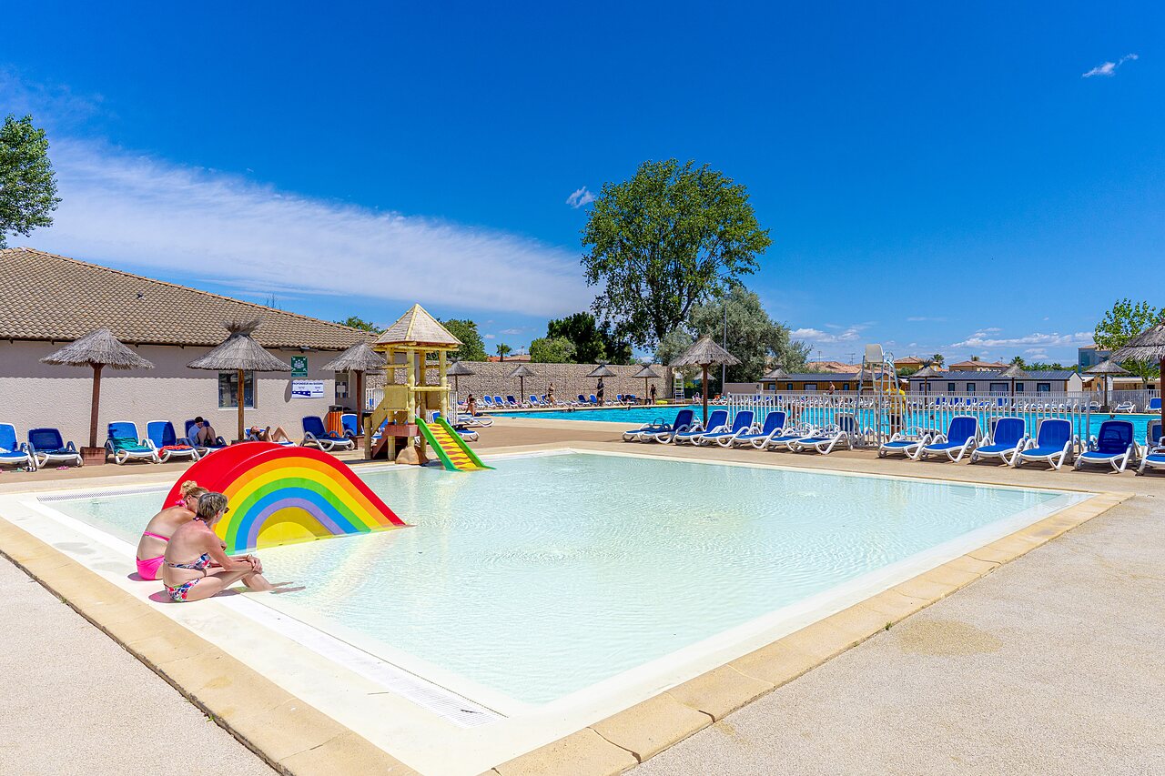 Piscina exterior, tobog�n arco�ris, juegos en el camping VAGUES OCEANES Elys�e, Grau du Roi.