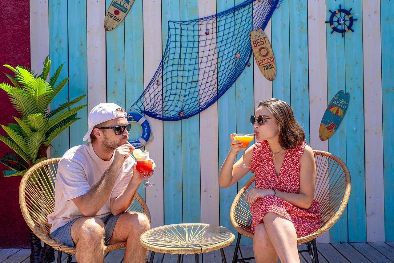 Pareja disfrutando c�cteles en el bar exterior decorado en el camping VAGUES OCEANES Elys�e en Le Grau du Roi (30).