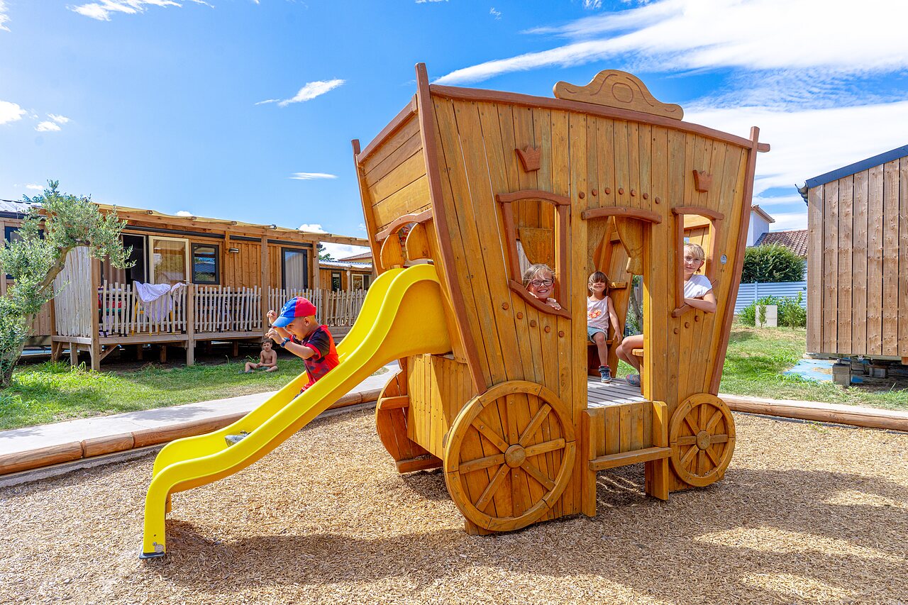 Ni�os en �rea de juegos carruaje de madera, tobog�n en el camping VAGUES OCEANES Elys�e en Le Grau du Roi (30).