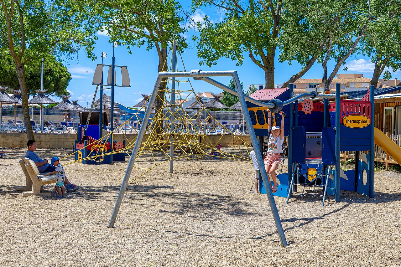 Zona de juegos infantiles con red de escalada en el camping VAGUES OCEANES Elys�e en Le Grau du Roi (30).