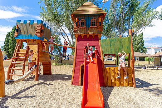 Zona de juegos de madera, tobogán, niños en el camping VAGUES OCEANES Elysée, Le Grau du Roi.