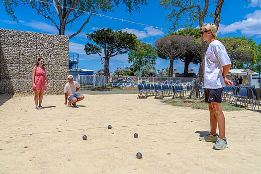 Campo de petanca con jugadores en el camping VAGUES OCEANES Elysée en Le Grau du Roi.