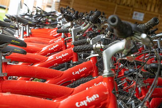 Bicicletas rojas Capfun alineadas para alquiler en el camping CAPFUN El Moli en Elne (66).
