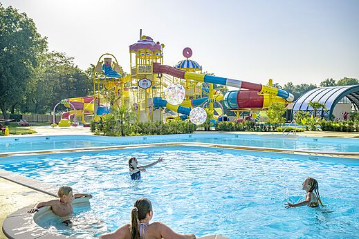 Toboganes acuáticos coloridos y piscina familiar exterior en el camping CAPFUN Erkemederstrand en Zeewolde.