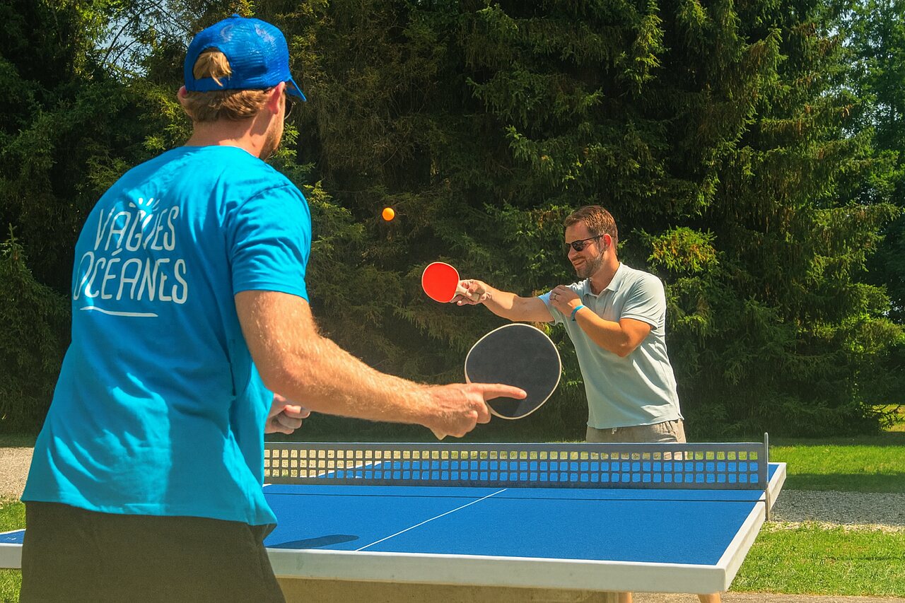 Animado partido de ping-pong al aire libre en el camping VAGUES OCEANES Lac d'Erstein (67).