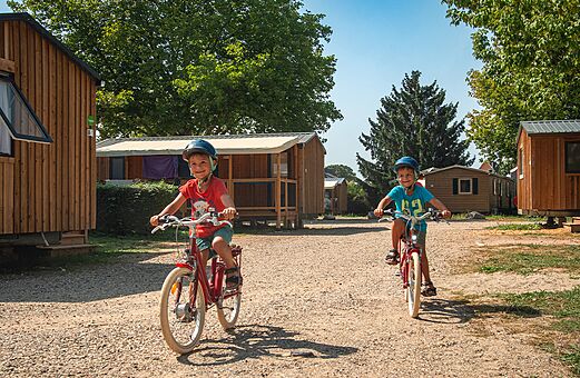 Niños en bicicleta en el camping VAGUES OCEANES Lac d'Erstein en Erstein (67).