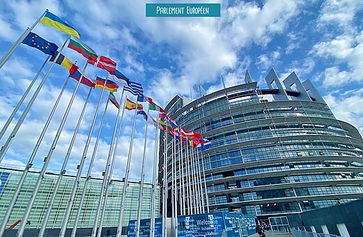 Edificio del Parlamento Europeo con banderas en Estrasburgo, lugar para visitar en Alsacia.