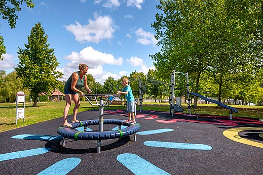 Zona de juegos moderna con mujer y niño en el camping CLICOCHIC Etang de la Mutche en HARPRICH (57).