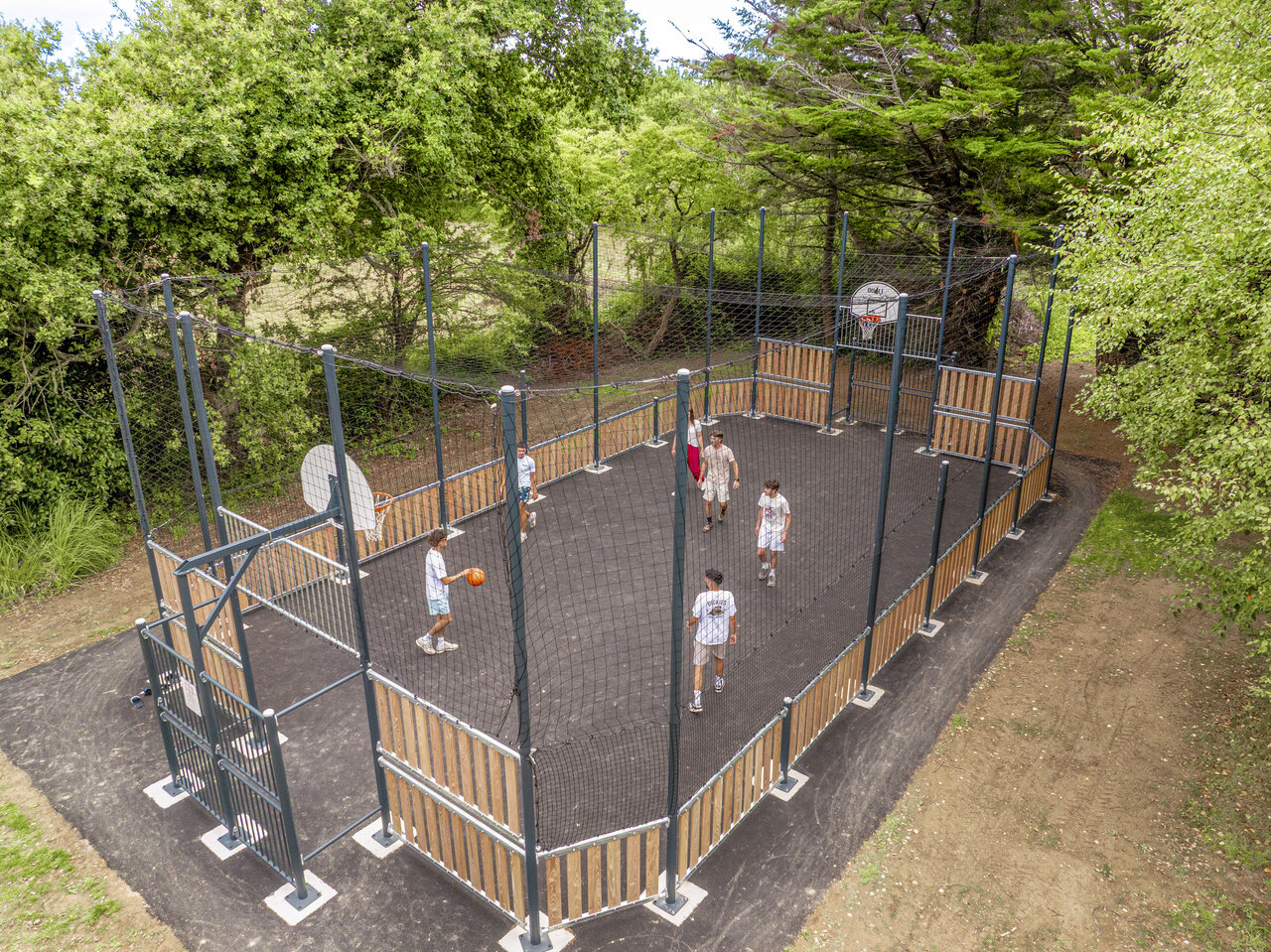 Cancha multideportiva con j�venes jugando baloncesto en el camping CLICOCHIC Etoile de Mer, Asserac (44).