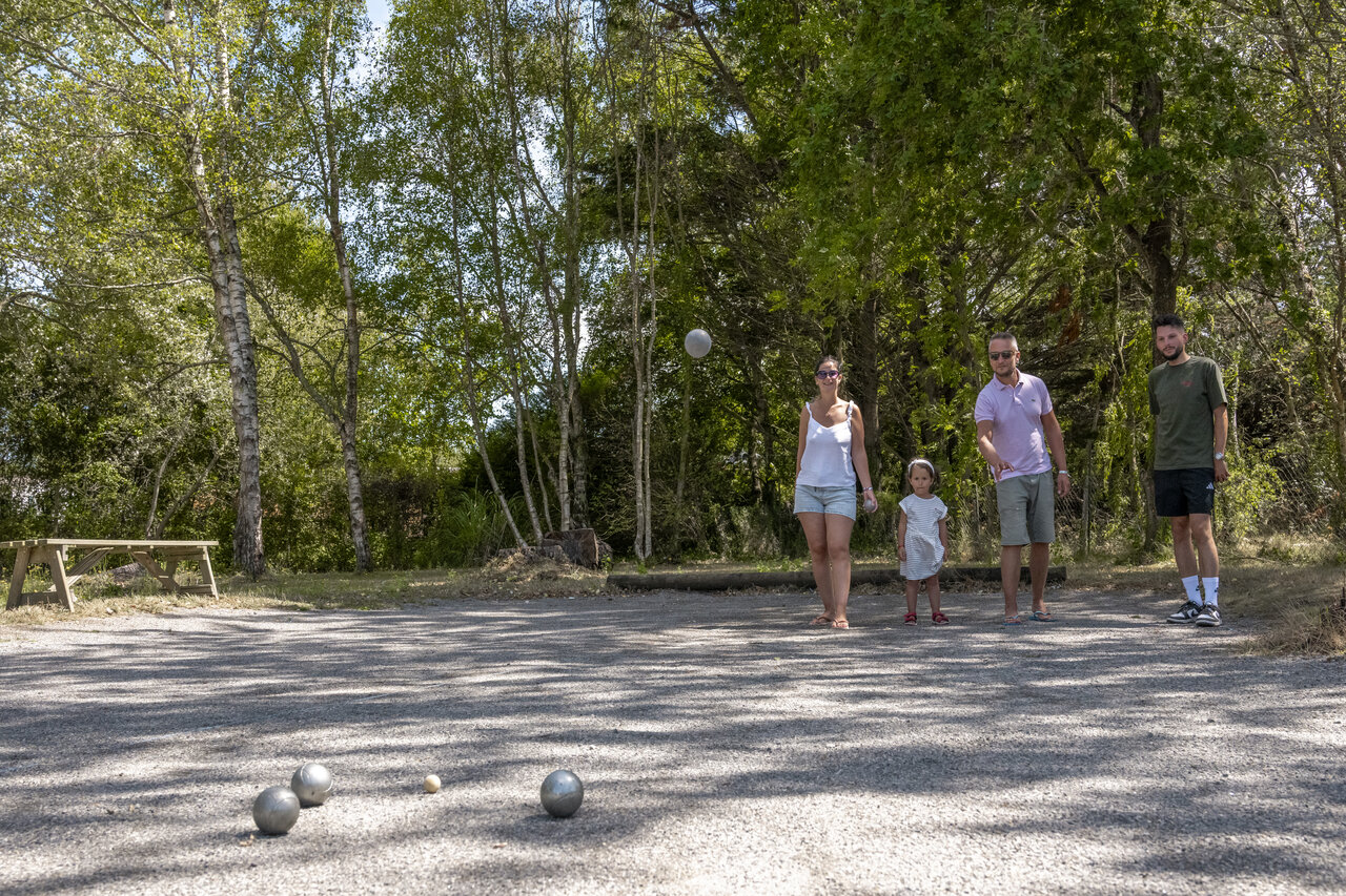 Familia jugando petanca en pista de grava en camping CLICOCHIC Etoile de Mer.