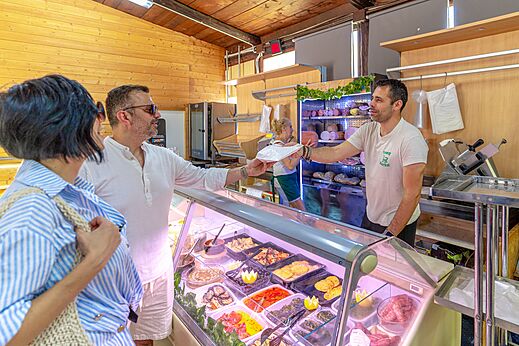 Cliente comprando platos preparados en la tienda, camping CAPFUN Europing en Tarquinia.