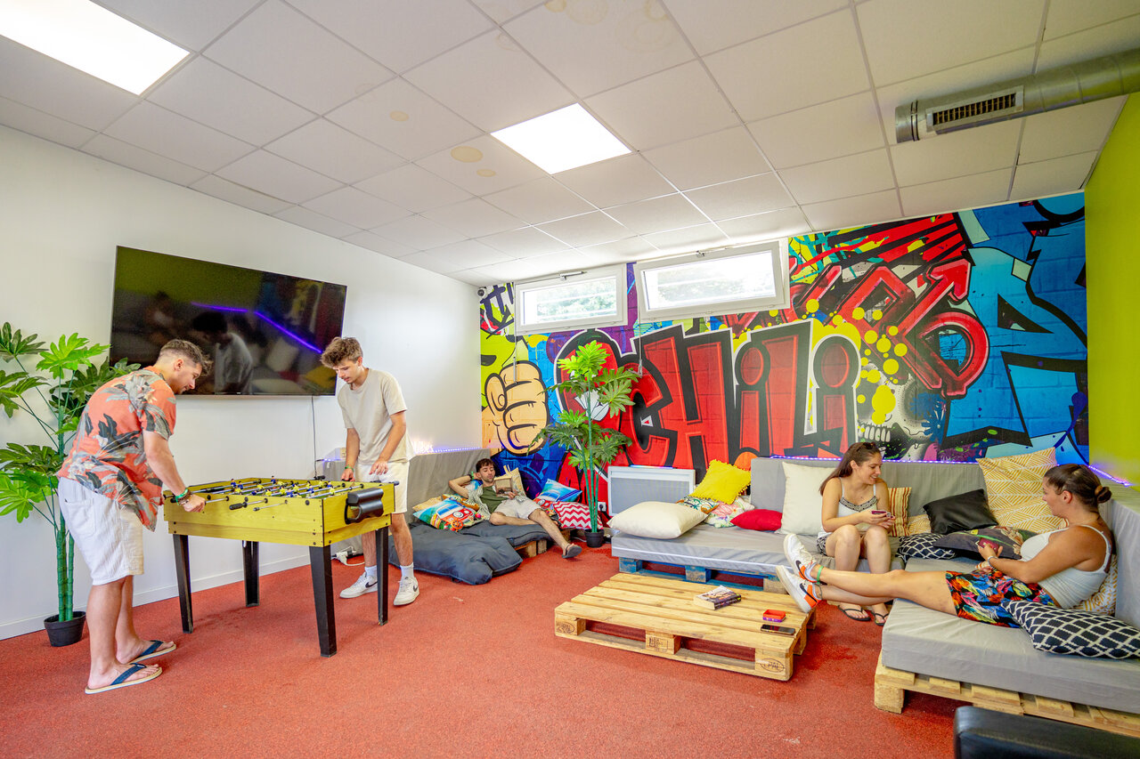 Futbol�n y �rea de descanso en sala de juegos del camping CAPFUN L'Eve.