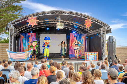 Espectáculo de animación en escenario exterior con mascotas y artistas en camping CAPFUN L'Eve en Saint-Marc-sur-Mer (44).