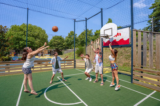 Jugadores de baloncesto en cancha multideportiva en camping CAPFUN L'Eve en Saint-Marc-sur-Mer (44).