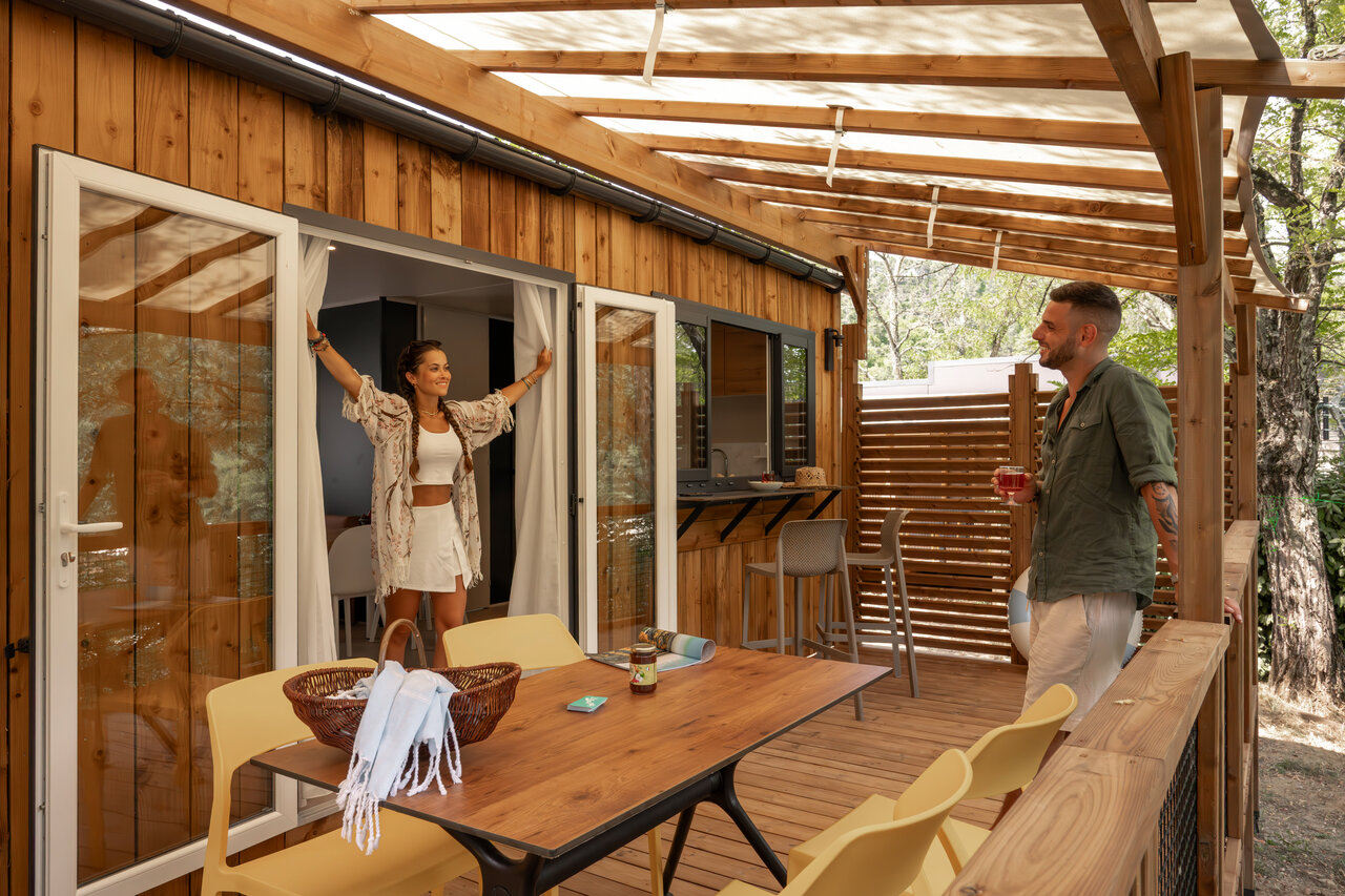 Mobile home moderno con amplia terraza de madera en el camping CLICOCHIC Eyrieux en Les OLLIERES-SUR-EYRIEUX.