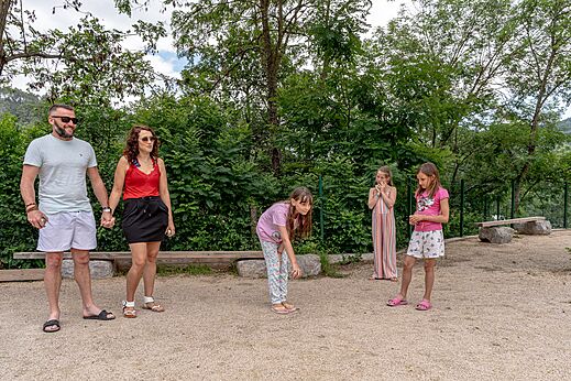 Familia jugando a la petanca en la cancha del camping CLICOCHIC Eyrieux.