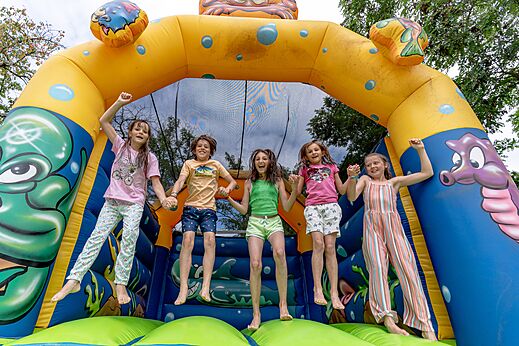 Castillo hinchable y niños felices en el camping CLICOCHIC Eyrieux en Les OLLIERES-SUR-EYRIEUX.