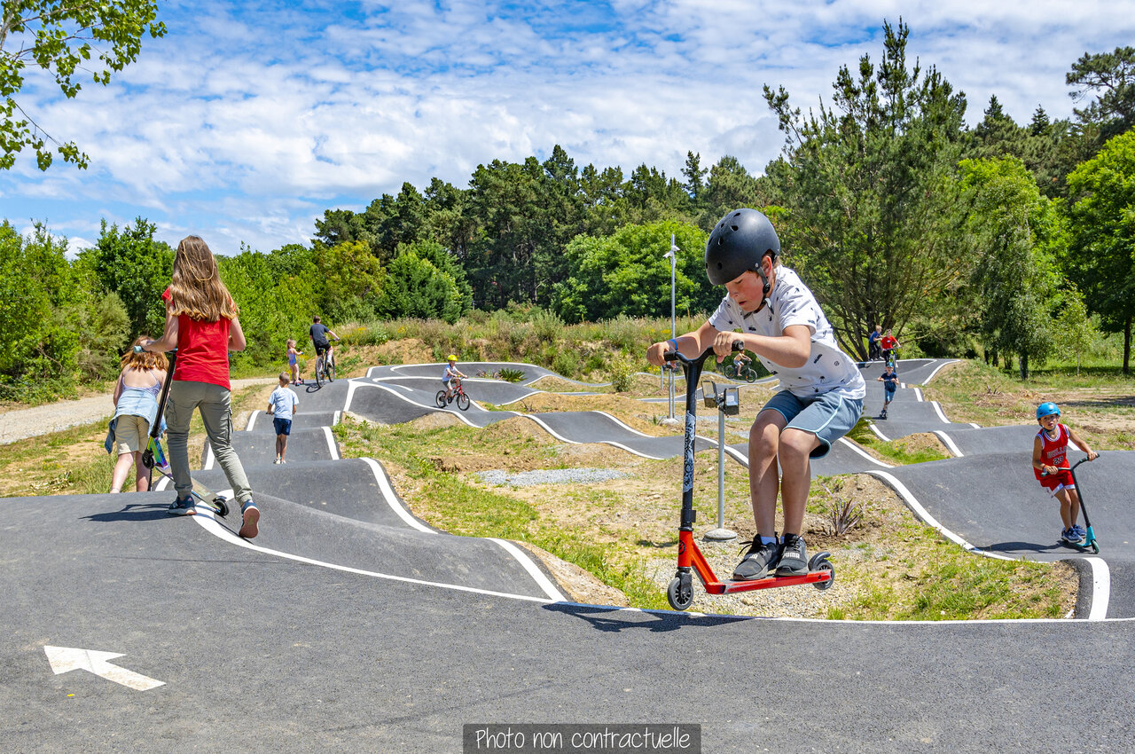 Ni�os en pump track con patinetes y bicicletas en el camping CAPFUN Falaises en Gonneville sur Mer.