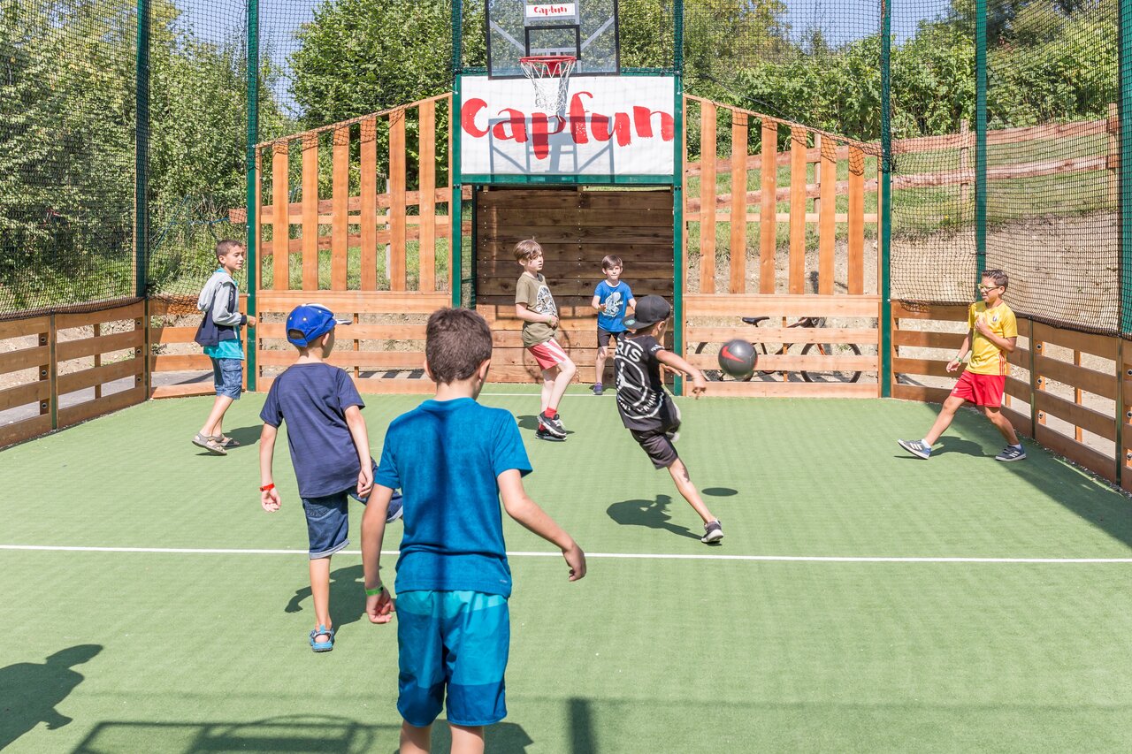 Ni�os jugando f�tbol en campo multideportivo en camping CAPFUN Falaises en Gonneville sur Mer (14).